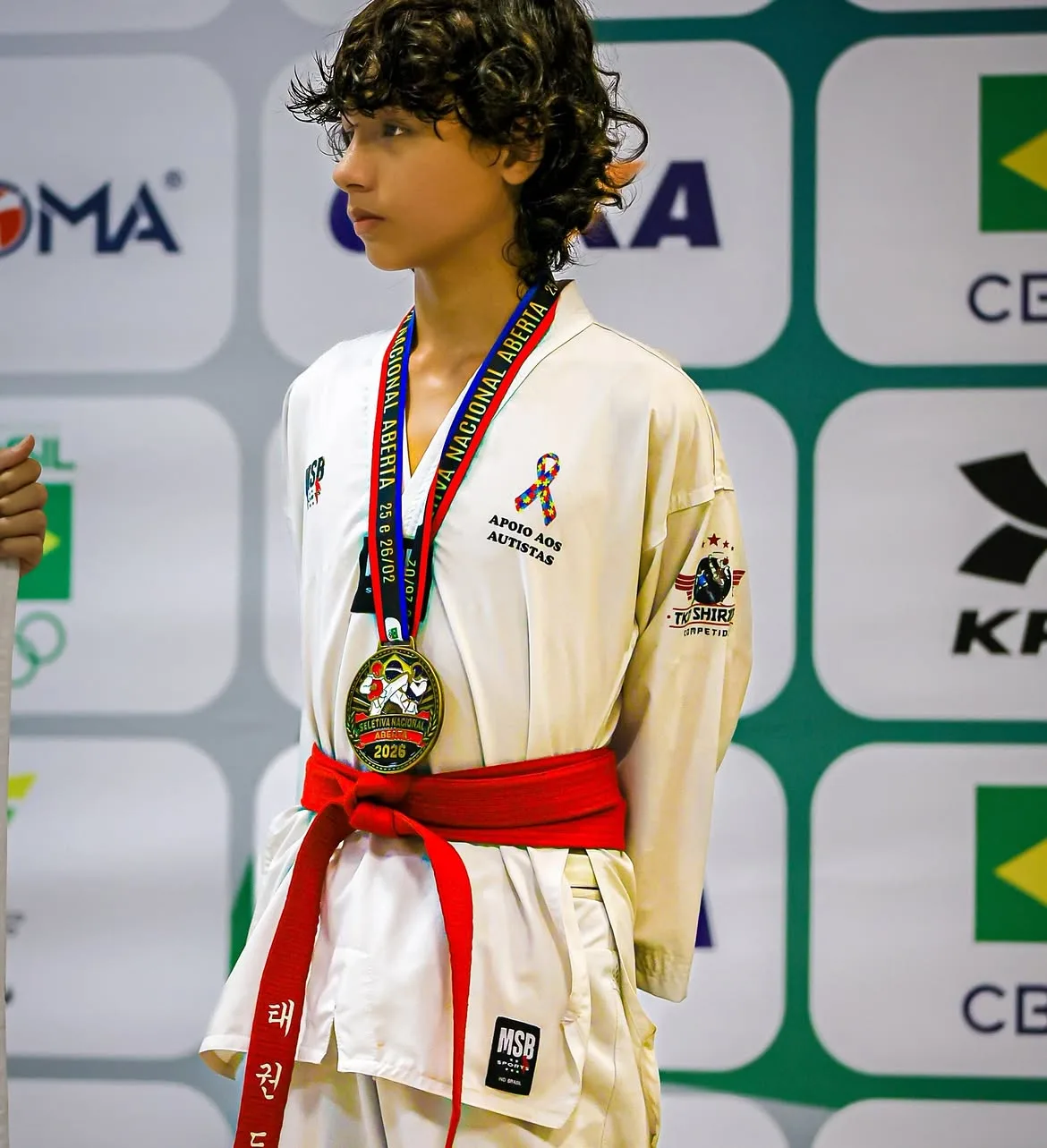 Atleta faixa vermelha no pódio da Seletiva Nacional Aberta, com a medalha no peito
