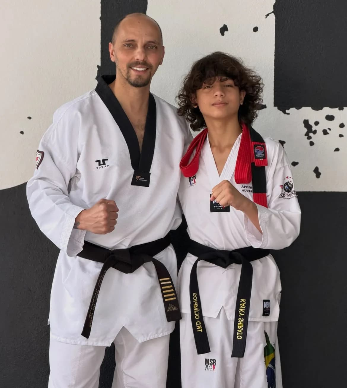 Professor do Instituto ao lado de atleta recém-graduado faixa preta