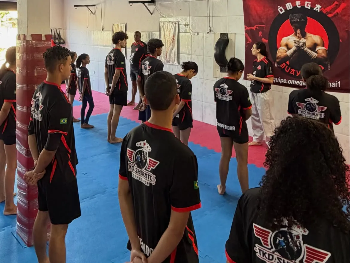 Turma do TKD Shirato Competidor perfilada no início do treino, de uniforme preto e vermelho