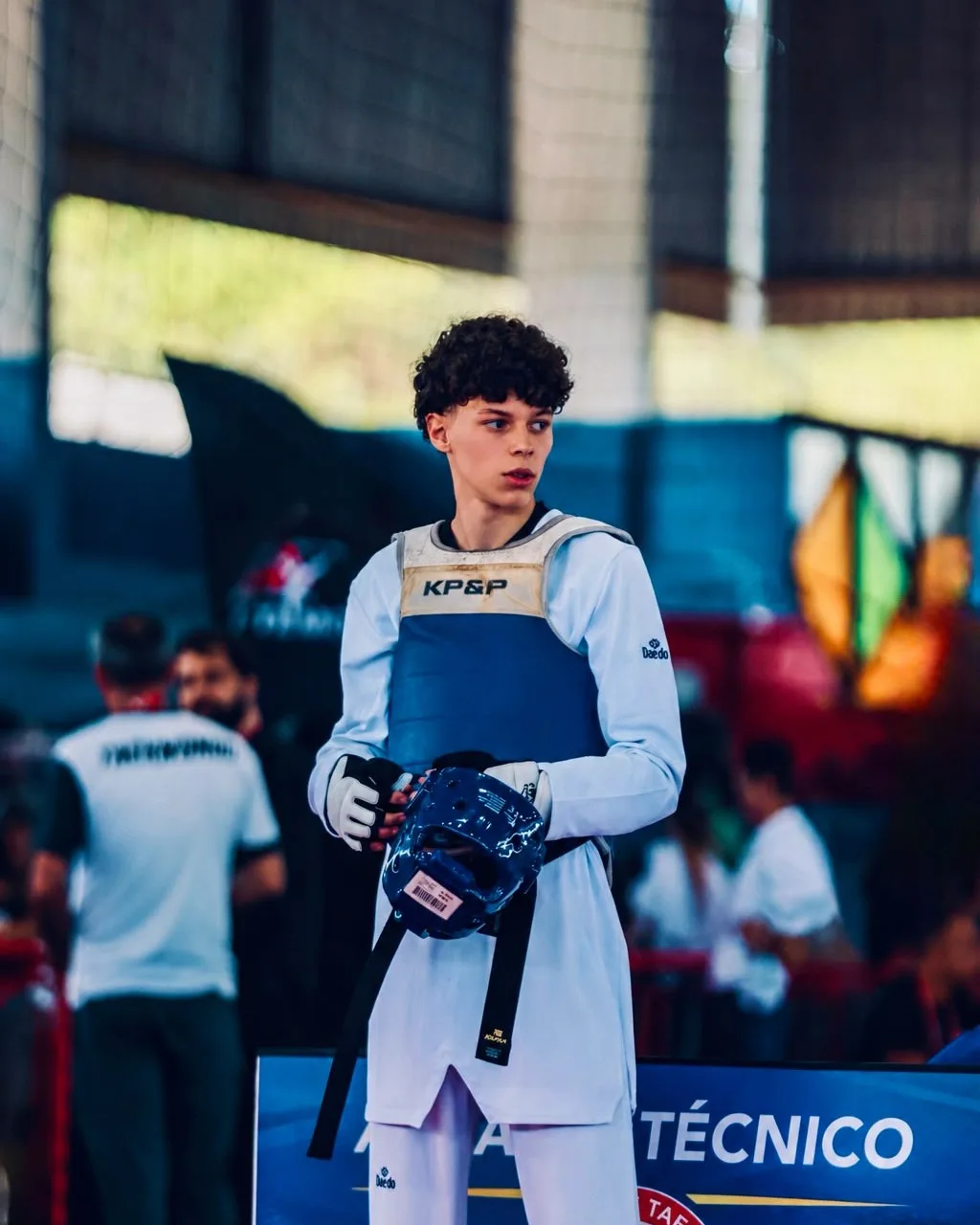 Rafael Peçanha de protetor de tronco azul, esperando a chamada para a luta na beira do tatame